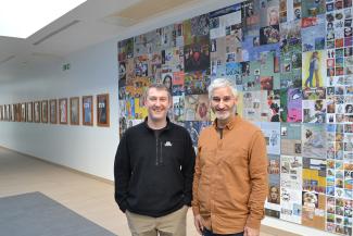 Two men standing in front of artwork