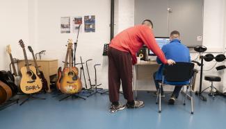 two men sitting at a computer