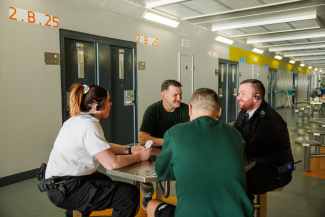 2 prisoners and 2 prison officers sitting talking round a table