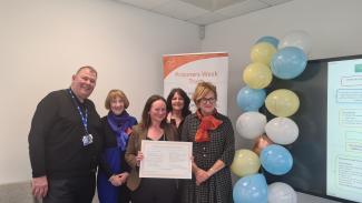 5 individuals standing with signed charity charter