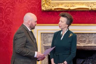Man receiving award from Princess Anne