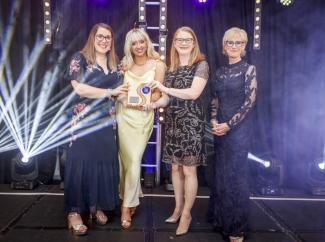 two women receiving award at ceremony