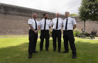 four prison officers in uniform