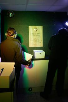 two officers with headsets on in dark room