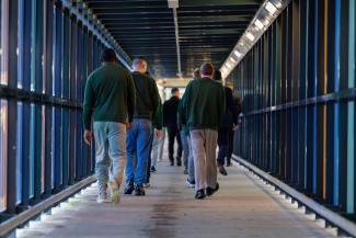 men walking down a prison corridor