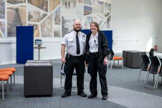 two uniformed staff standing in a visit room